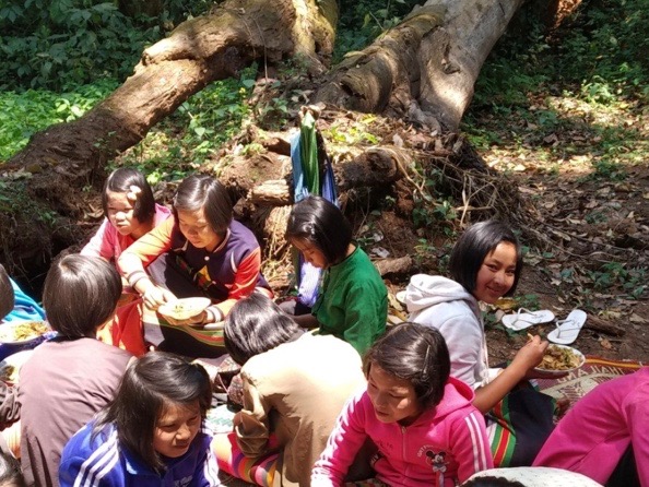 Summer students practicing their conversational English and enjoying a snack in the outdoor classroom.